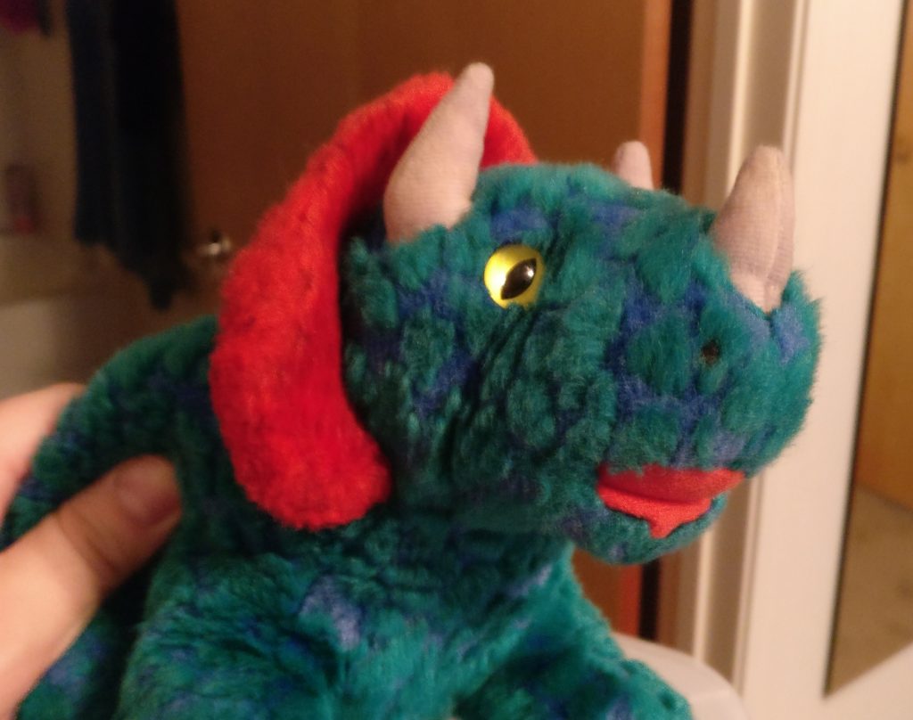 My stuffed dinosaur Harold, a green, blue, and red stuffed animal. I discovered him after digging through some things and took this picture to show a friend.