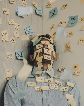 Sticky notes all over a tired person's face