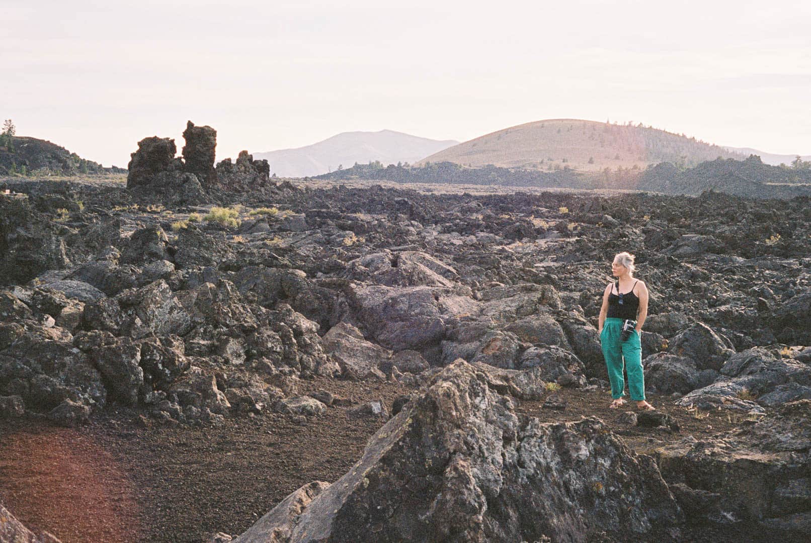 A woman standing in front of a volcanic pillar