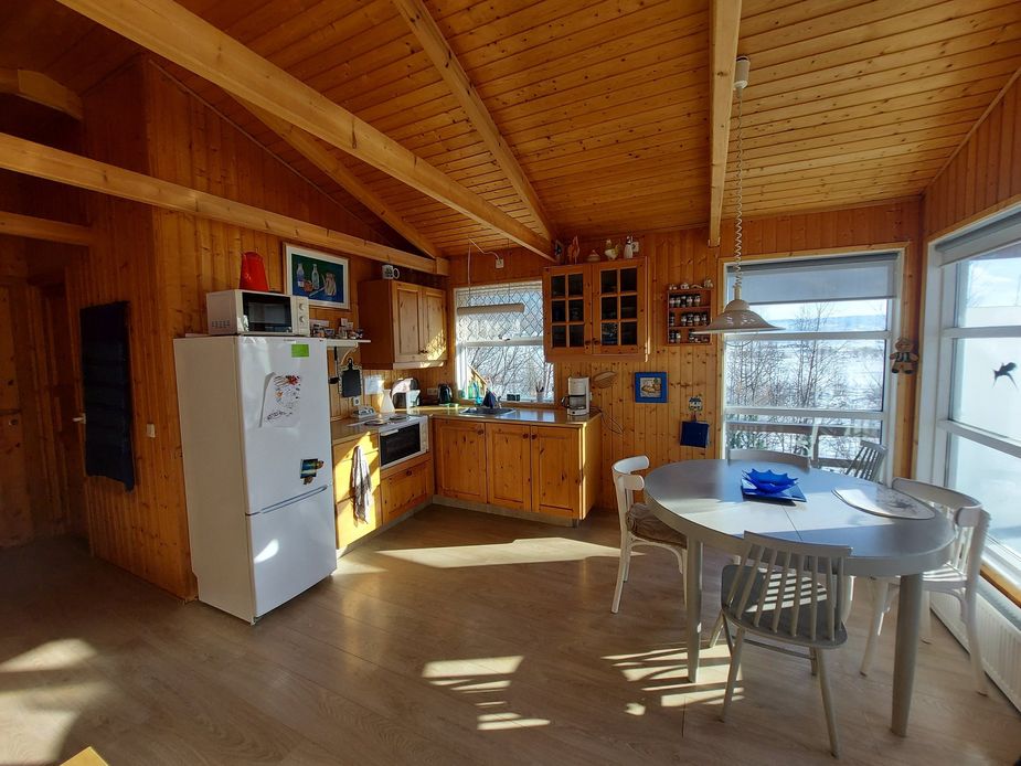 Die Küche mit allem, was zum Kochen benötigt wird, und der Essbereich mit großen Fenstern und Aussicht