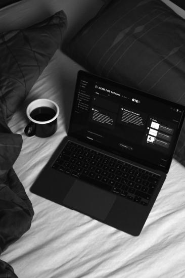 Laptop and coffee on a bed, with a code editor open.