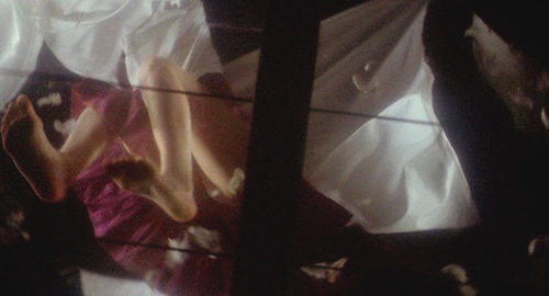 A screenshot of a chaotic scene shot from below of a girl being attacked by pillows and blankets. From the Japanese film 'House'.