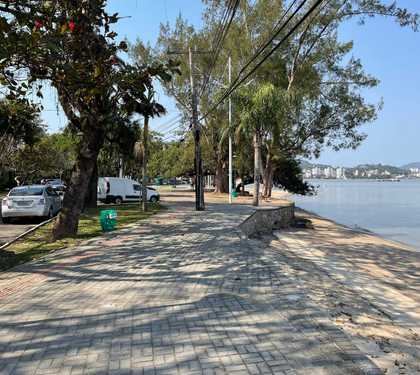 Calçadão da Tapera com arvores a faixa de area a direita mar calmo ao fundo