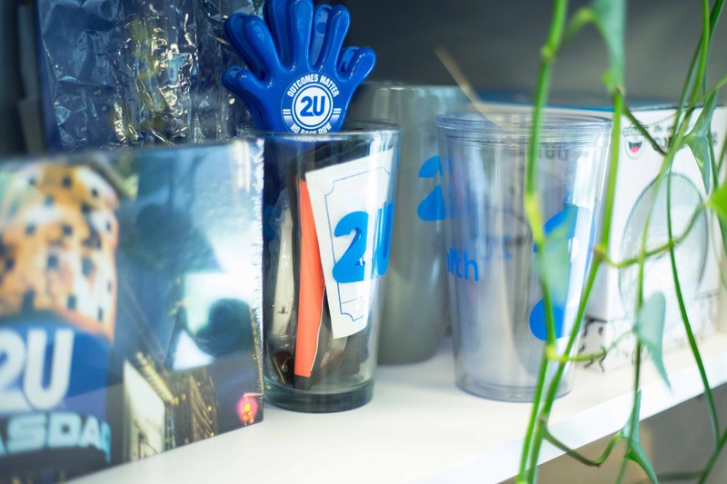A close up view of various 2U promotional giveaways on a shelf