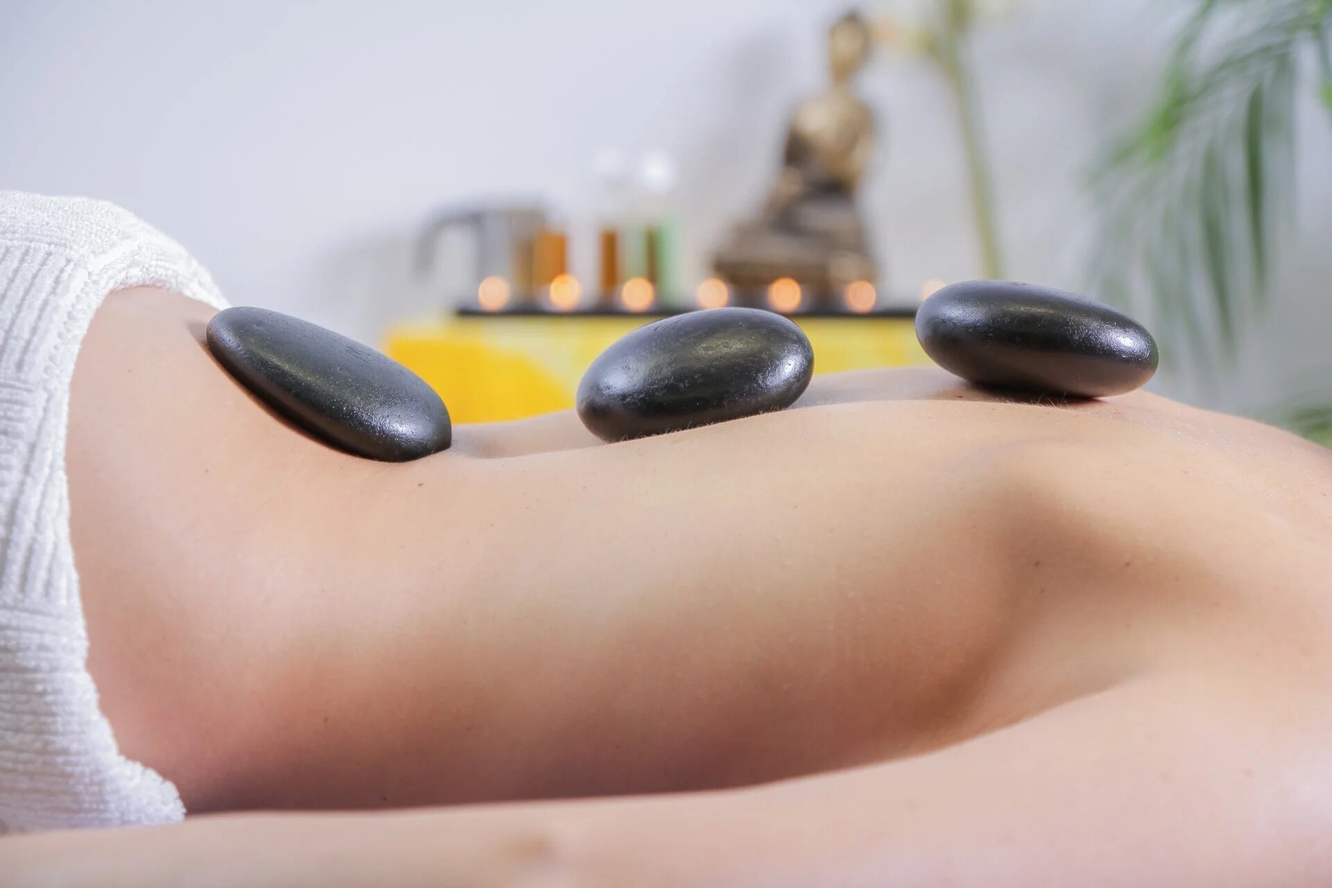 Customer laying down and receiving Traditional Chinese Medicine therapy with hot stones