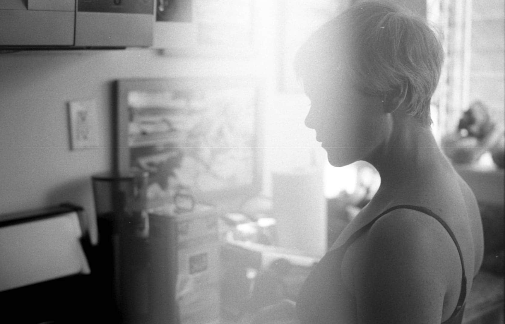 My wife in the kitchen. A light leak washed out part of the image in an artistic way.