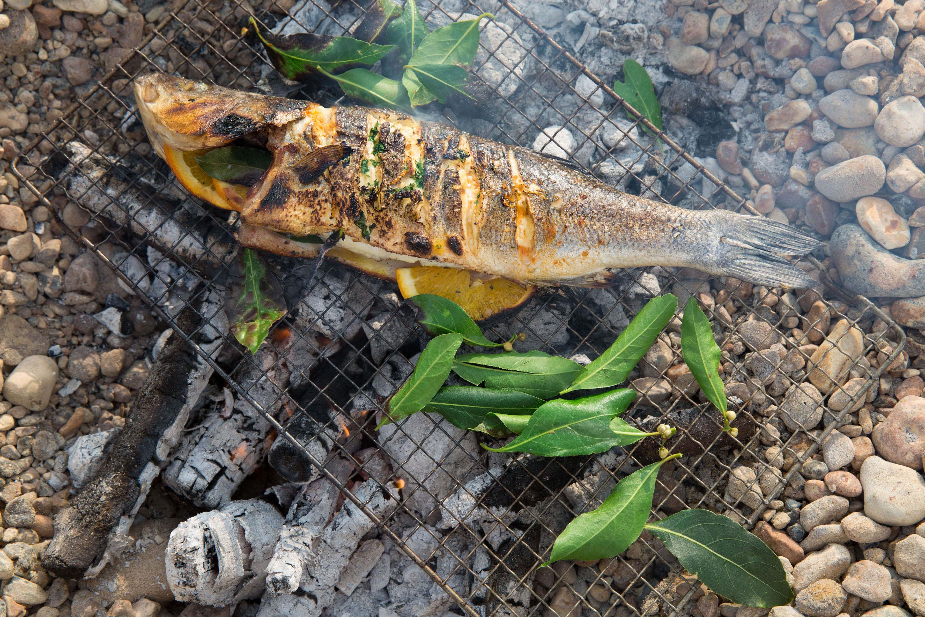 Seabass cooking on the bbq with bay leaves.