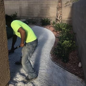 man leveling gravel for a walkway