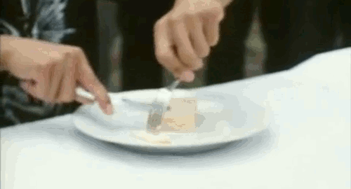 An animated gif of a scene from the Chinese film 'Frozen' of an artist eating soap with a knife and fork.