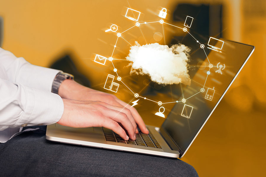 Man using laptop with cloud services graphic