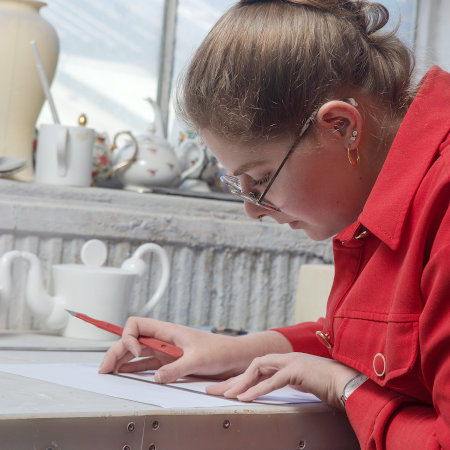 Francesca working on a ceramic design on paper.