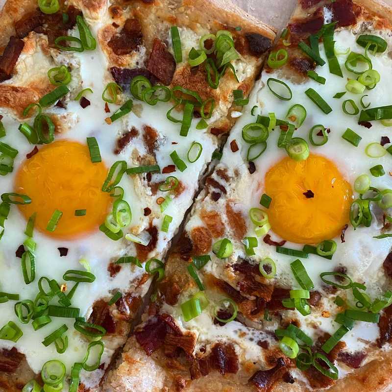 breakfast. pizza. 🍕🍳 parbaked with white sauce, mozz, and bacon. added the eggs for the last 5 minutes of baking. topped with the essential scallion.