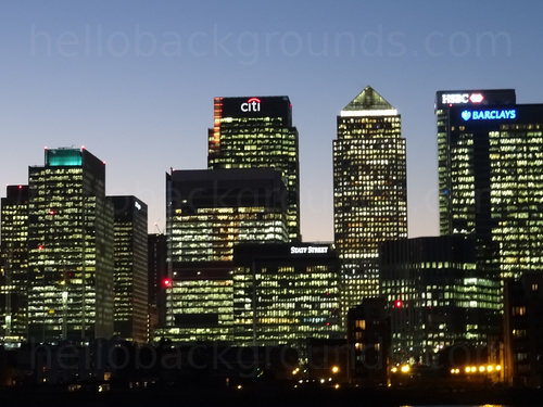 Urban cityscape at night featuring various tall buildings with some displaying lights from windows  Zoom background