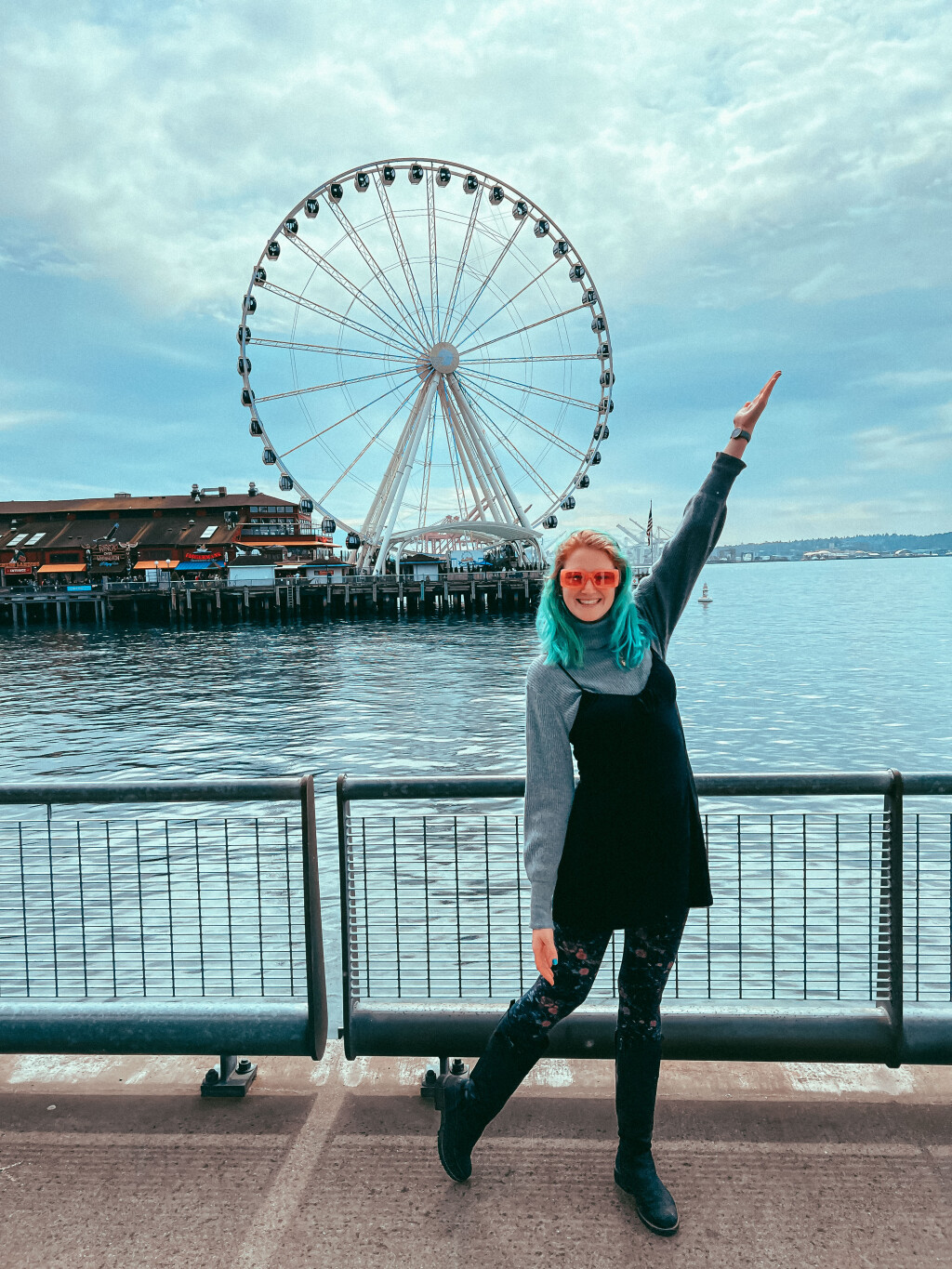 Beth's wearing a little black dress over a gray turtleneck, standing in front of the Seattle Wheel