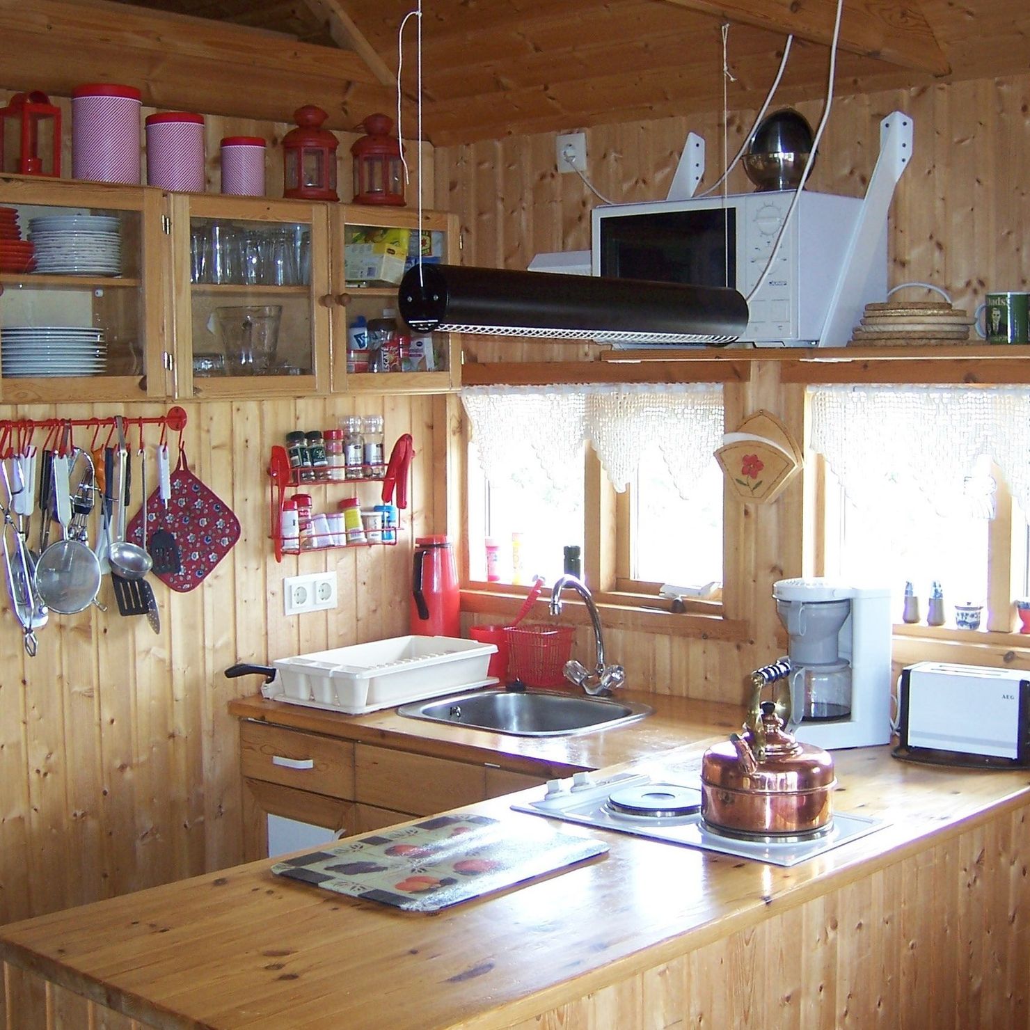 Helle Küche mit Mikrowelle und Herd mit zwei Kochplatten