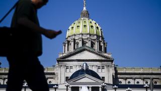 Man walks in front of Pennsylvania state capitol Man walks in front of Pennsylvania state capitol