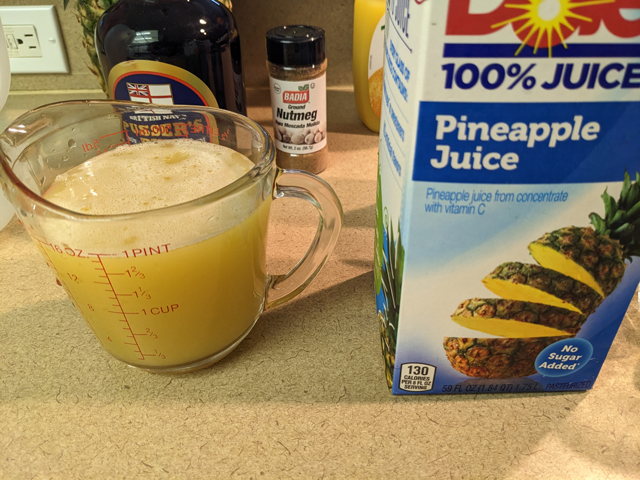 Making a Painkiller Step One: Pouring the Pineapple Juice