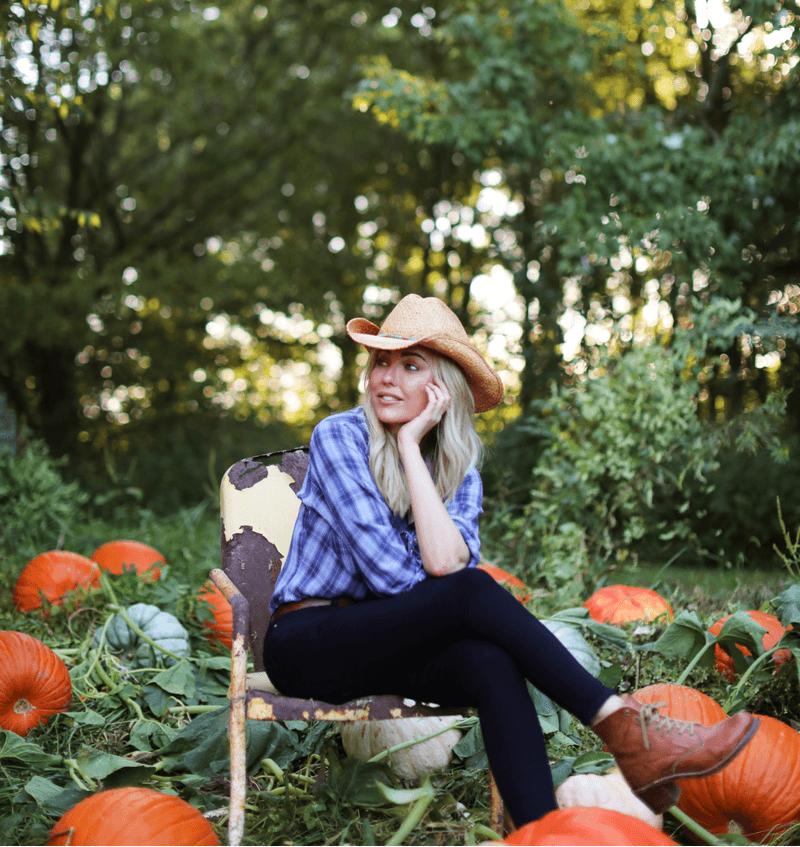 Sarah Frey sitting in a pumpkin field