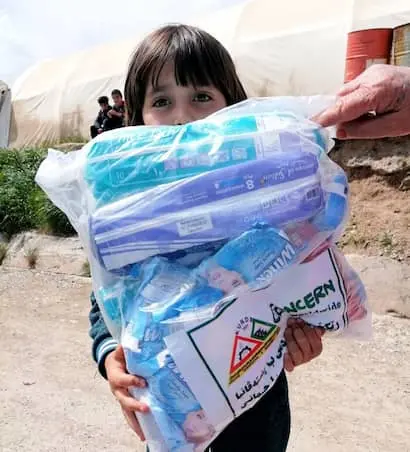 A young girl in an IDP camp in Northern Iraq receives a delivery of COVID-19 hygiene prevention kits.