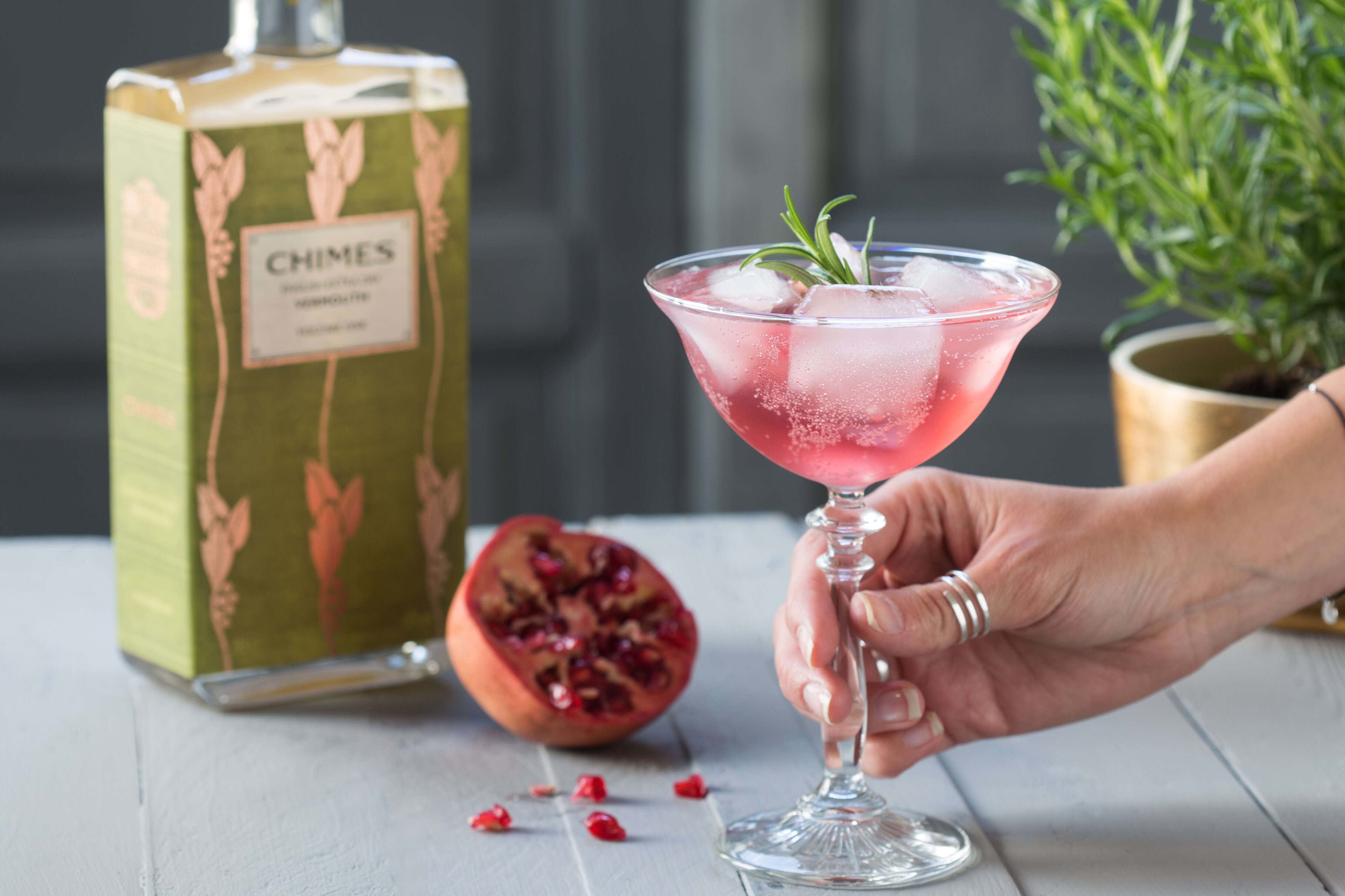 Chimes vermouth cocktail with pomegranate and tonic water set on a grey background