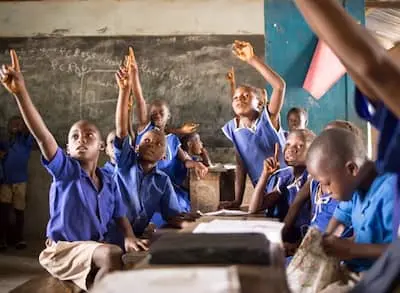 Students raising their hands in a classroom