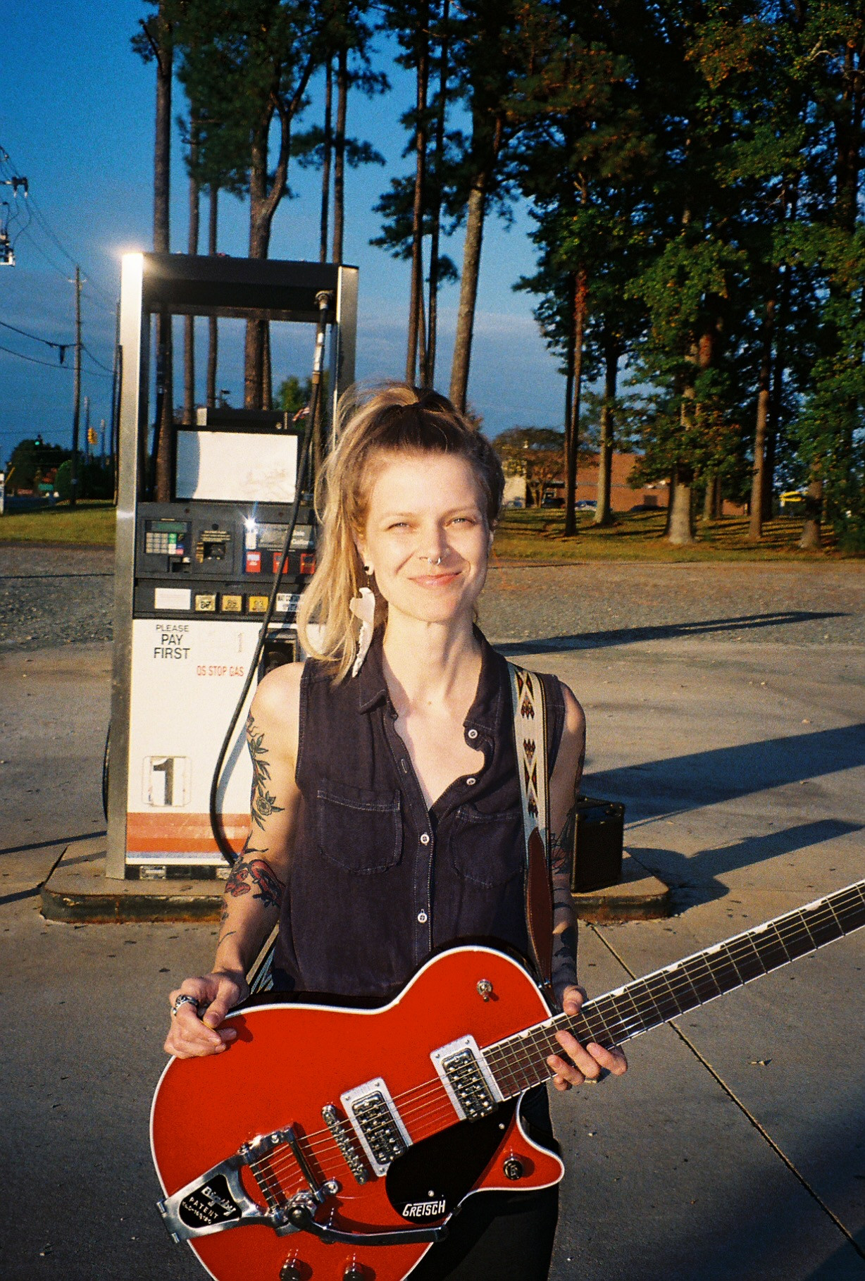 A woman holding a red electric guitar