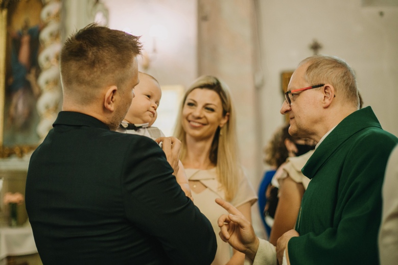 Sesja chrztu Poznań - ksiądz udziela dziecku sakrametu
