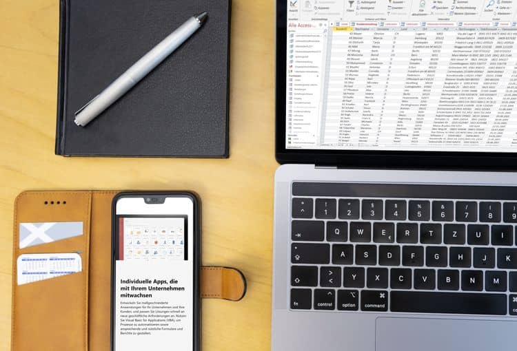 Access auf Laptop und Smartphone Schreibtisch mit Access auf Laptop und Smartphone und Stift