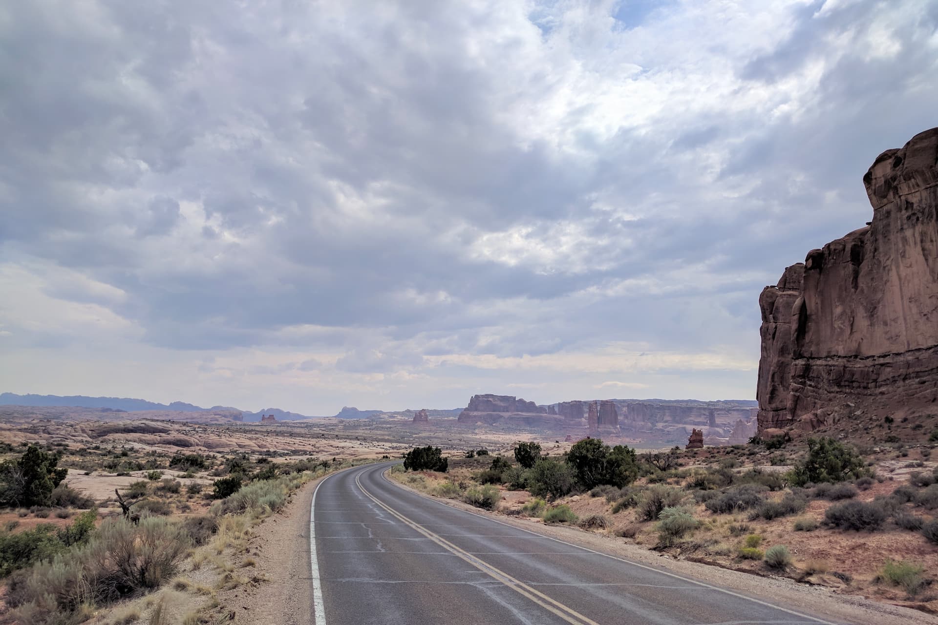 Looking south back along the main road into Arches National Park. In the distance, massive fins of red sandstone.
