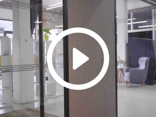 Meeting room with interior floor-to-ceiling windows overlooking modern office with purple armchair and white bookcase  Google Meet background