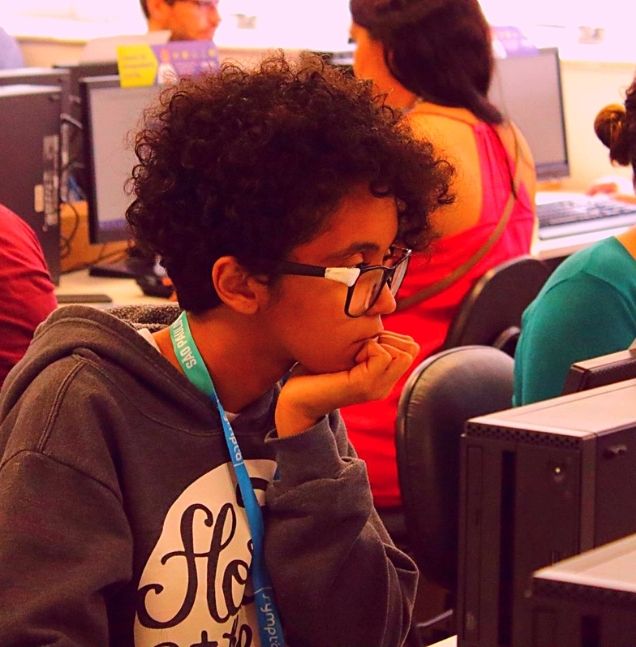 Mulher de óculos sentada na frente do computador, durante curso de programação realizado pela WoMakersCode