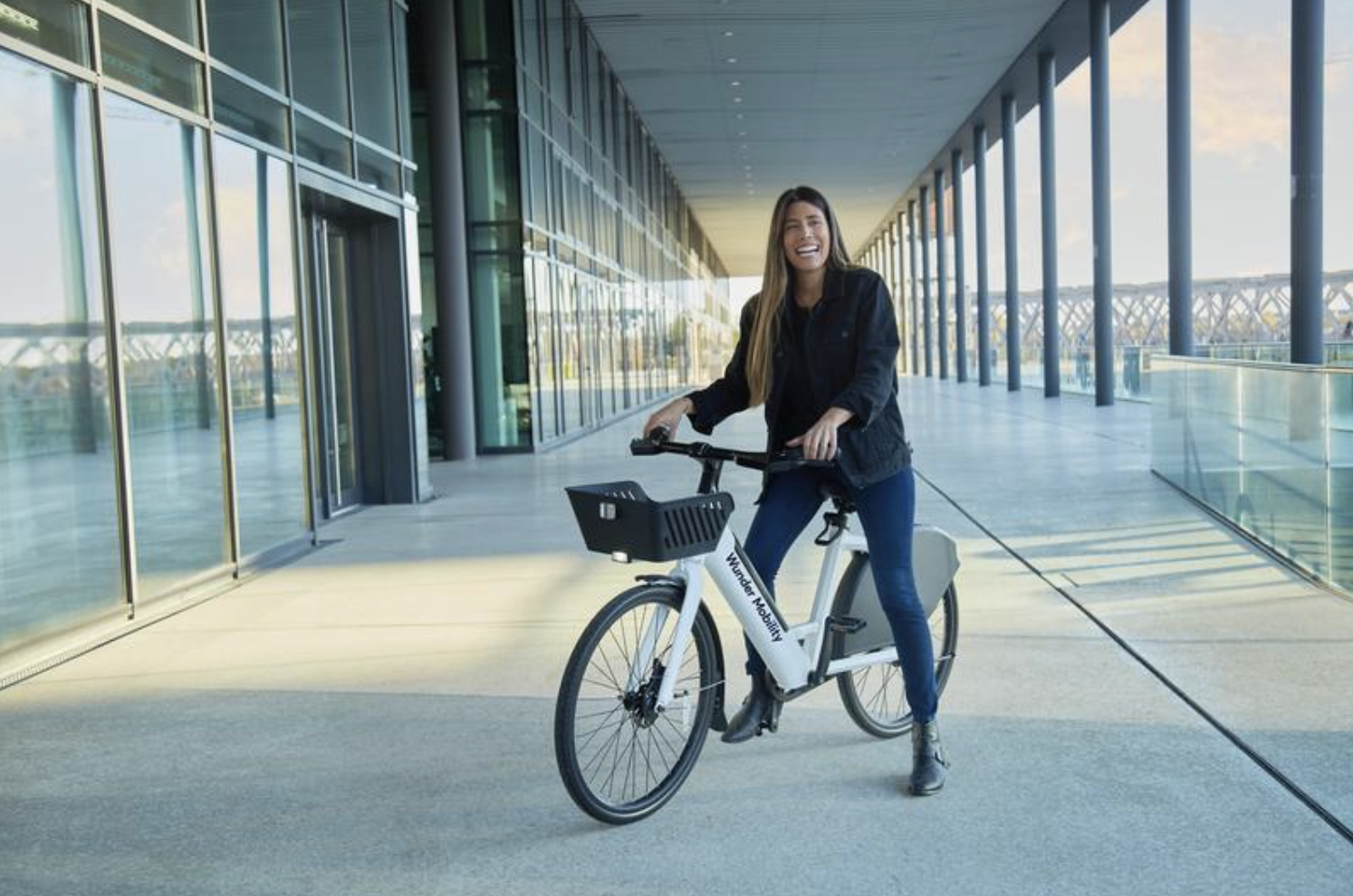 A female smiling and sitting on a Wunder Mobility eBike.