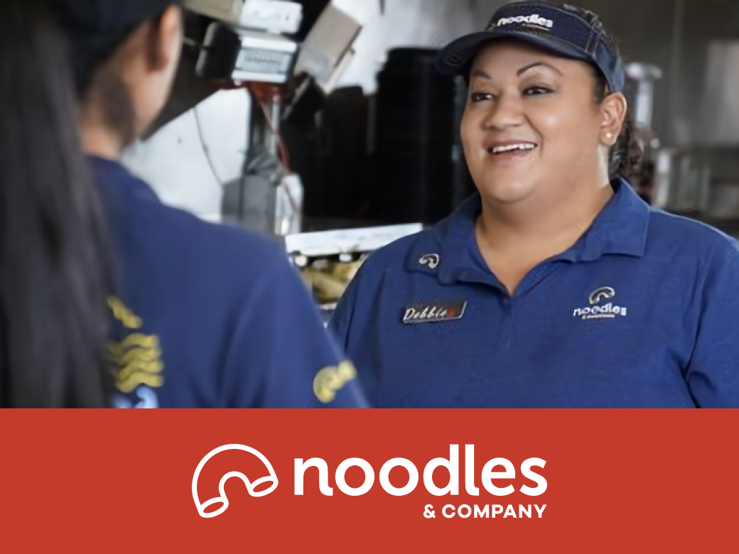 banner with coworkers huddled, viewing a document, with Noodles & Company logo