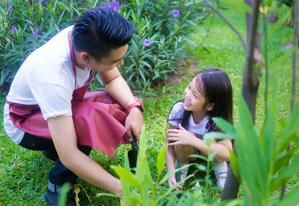 Young Asian father with his daughter having fun gardening