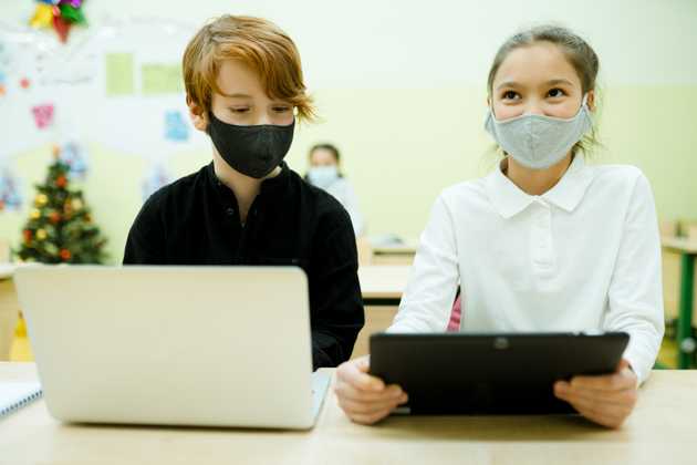 Two students with electronic devices