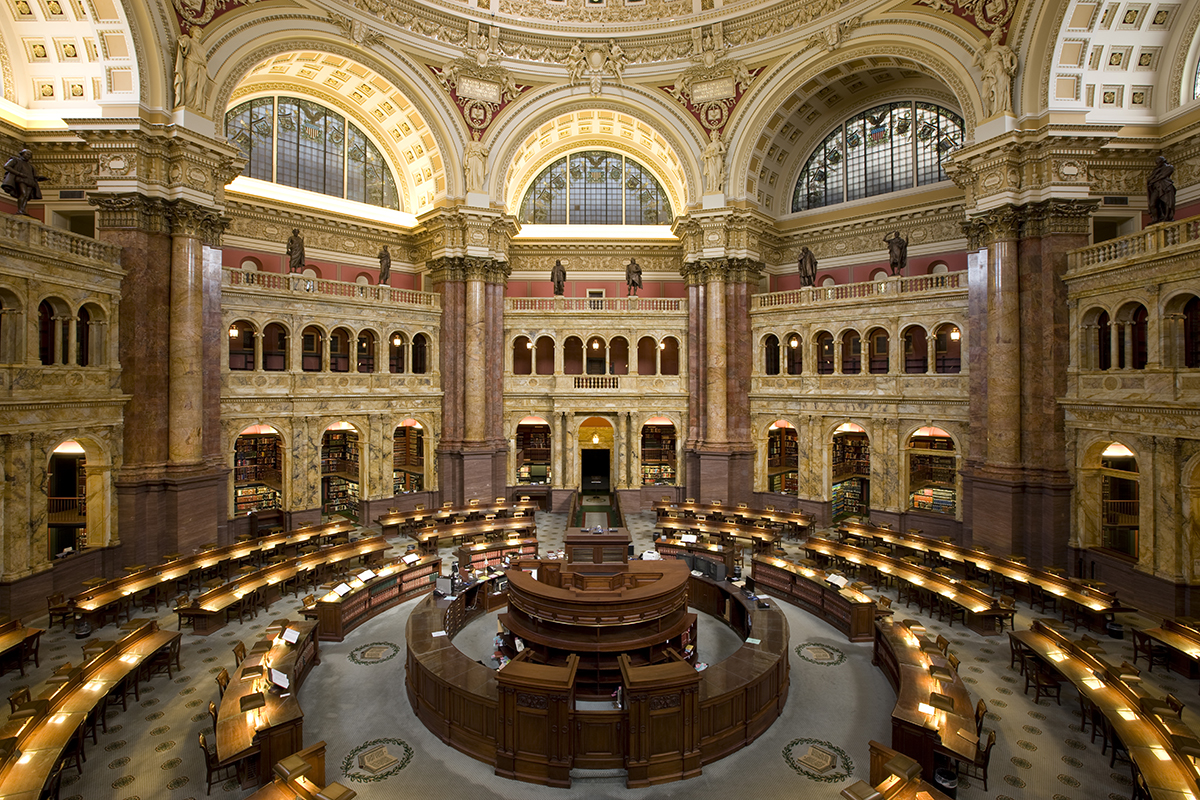 the library of congress reading room with rows of desks and the glow of table lamps in a round room with a high ceiling