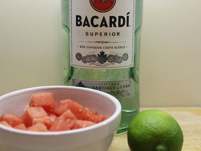 The Ingredients that go into making a Watermelon Daiquiri, including fresh watermelon, lime, and light rum