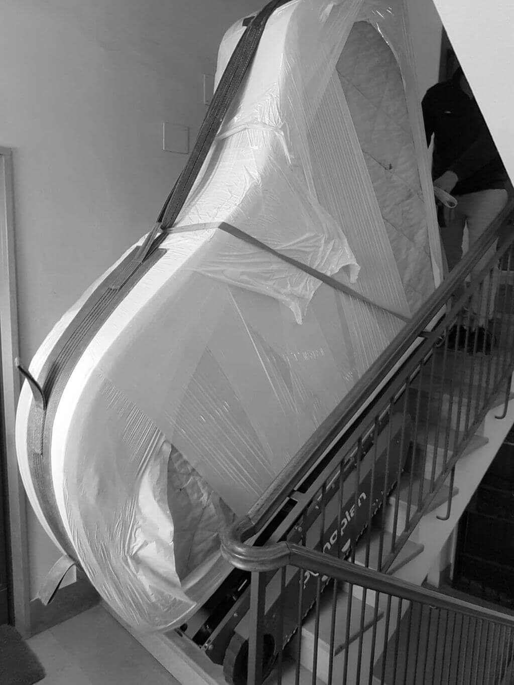 Persona che trasporta pianoforte a coda sulle scale