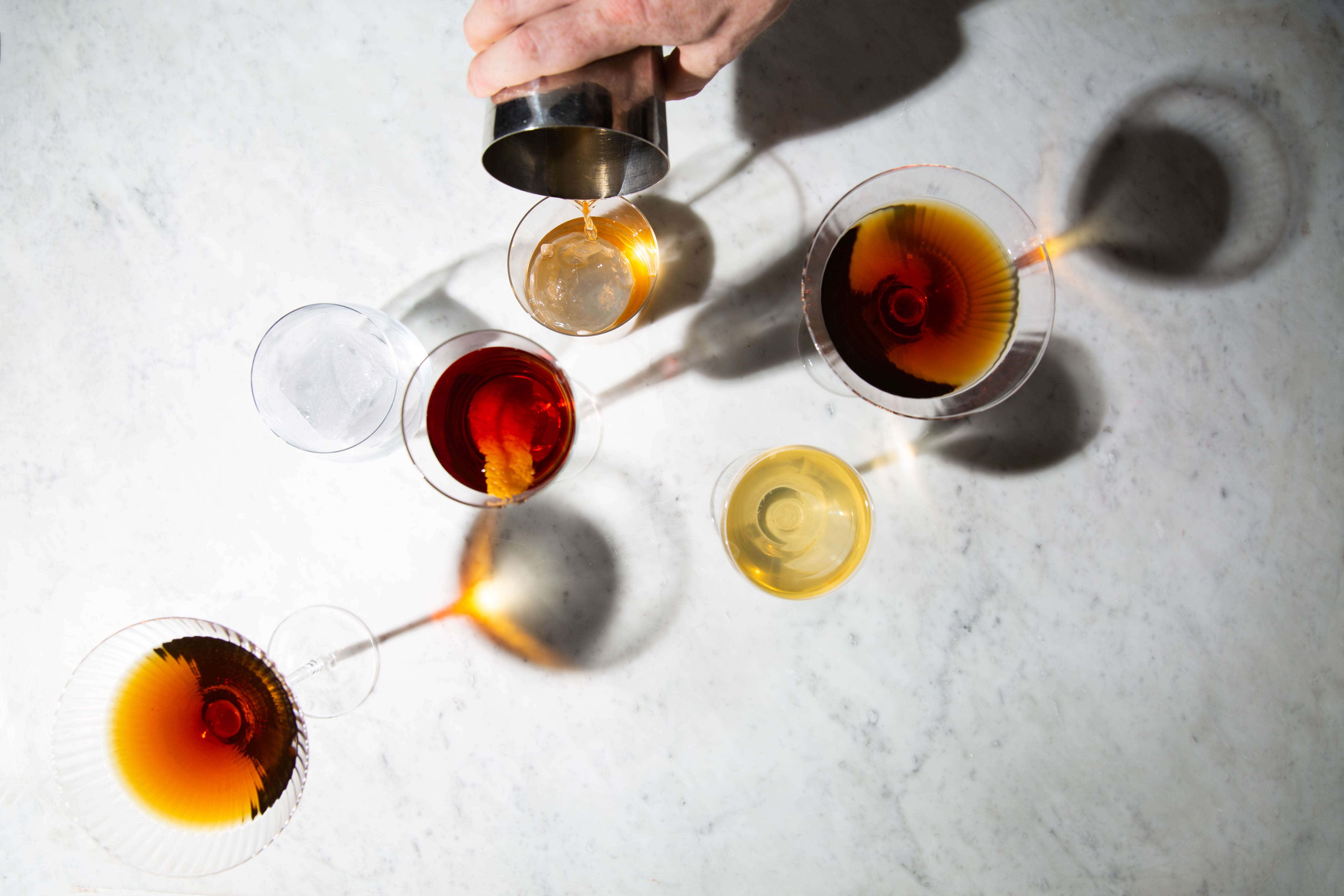 a selection of cocktails shot from above with one being poured