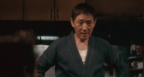 A screenshot from the film 'Midnight Diner' of the Japanese pub master (played by Kaoru Kobayashi) wearing a navy blue samue.