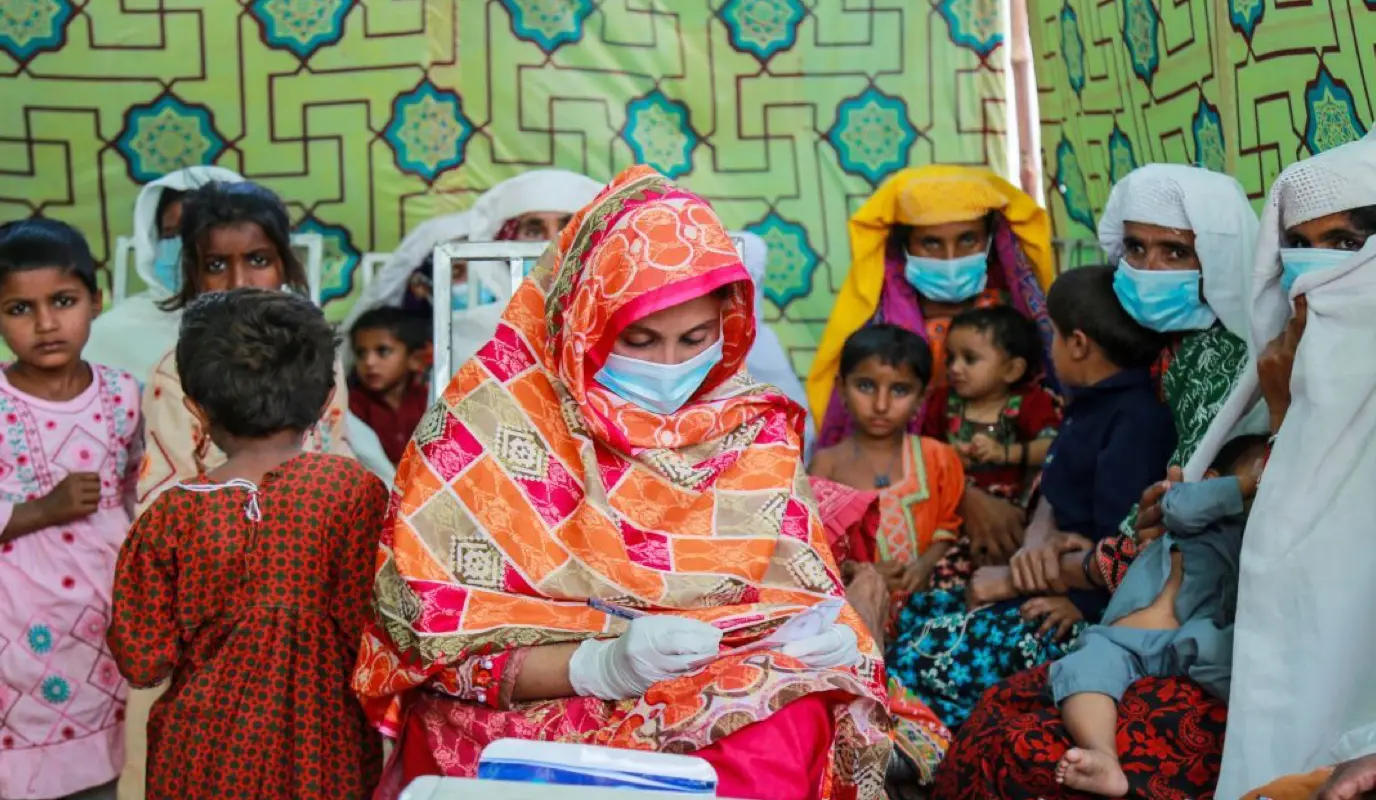 Rubina Baloch vaccinates a group of women and children at a health camp in Sindh Province