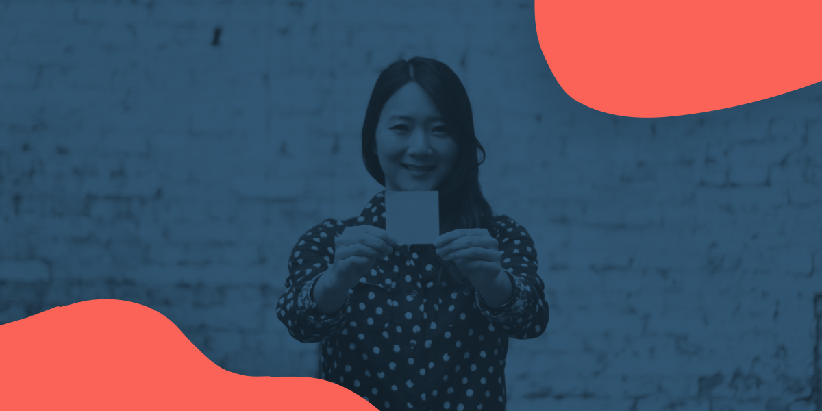 A UX Designer with a post-it note A woman UX Designer holds a post-it note out to the camera