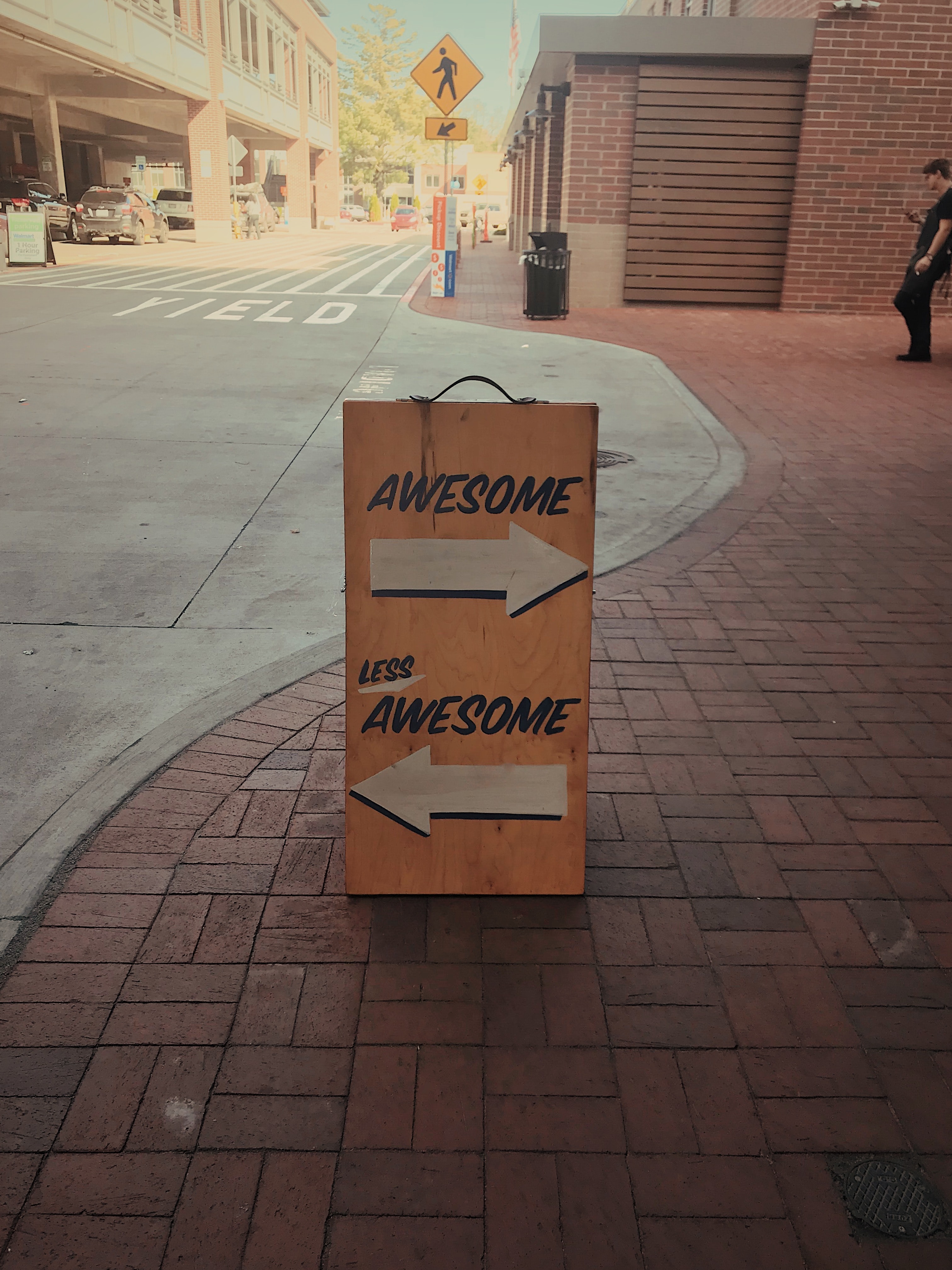Sign on a road saying 'awesome' and 'less awesome'