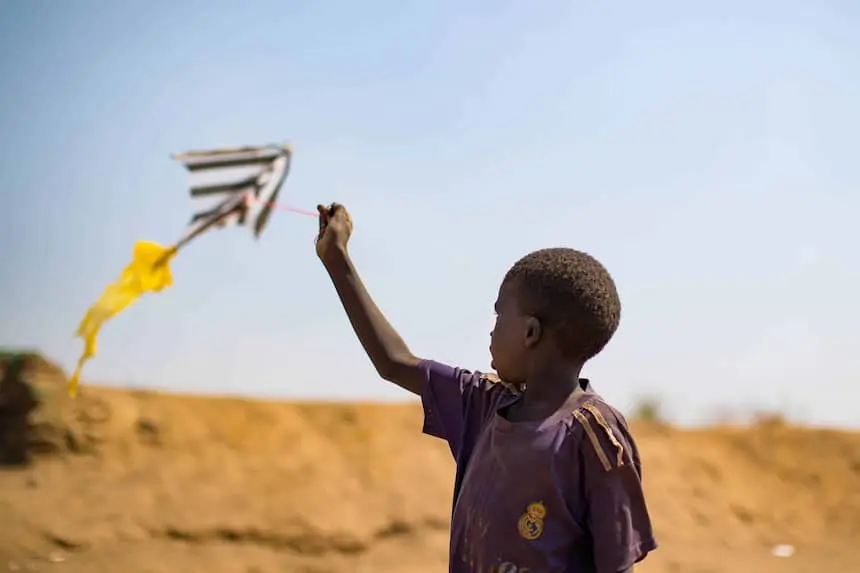 A child flies a homemade kite in a Protection of Civilians site in South Sudan.