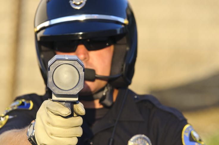Police officer holding radar gun