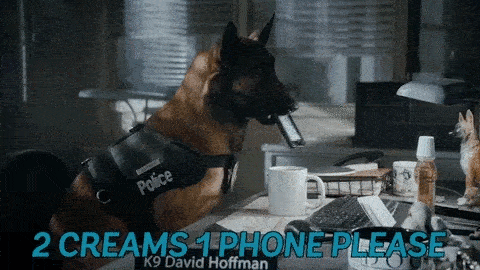 Un perro policía metiendo un teléfono celular en una taza de café