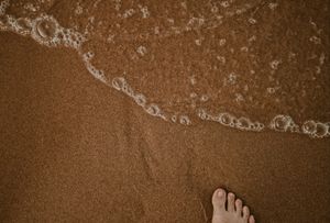 a foot near the water at the beach