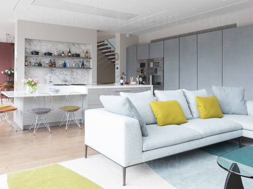 Contemporary living room kitchen area featuring white sofa and kitchen island Microsoft Teams background