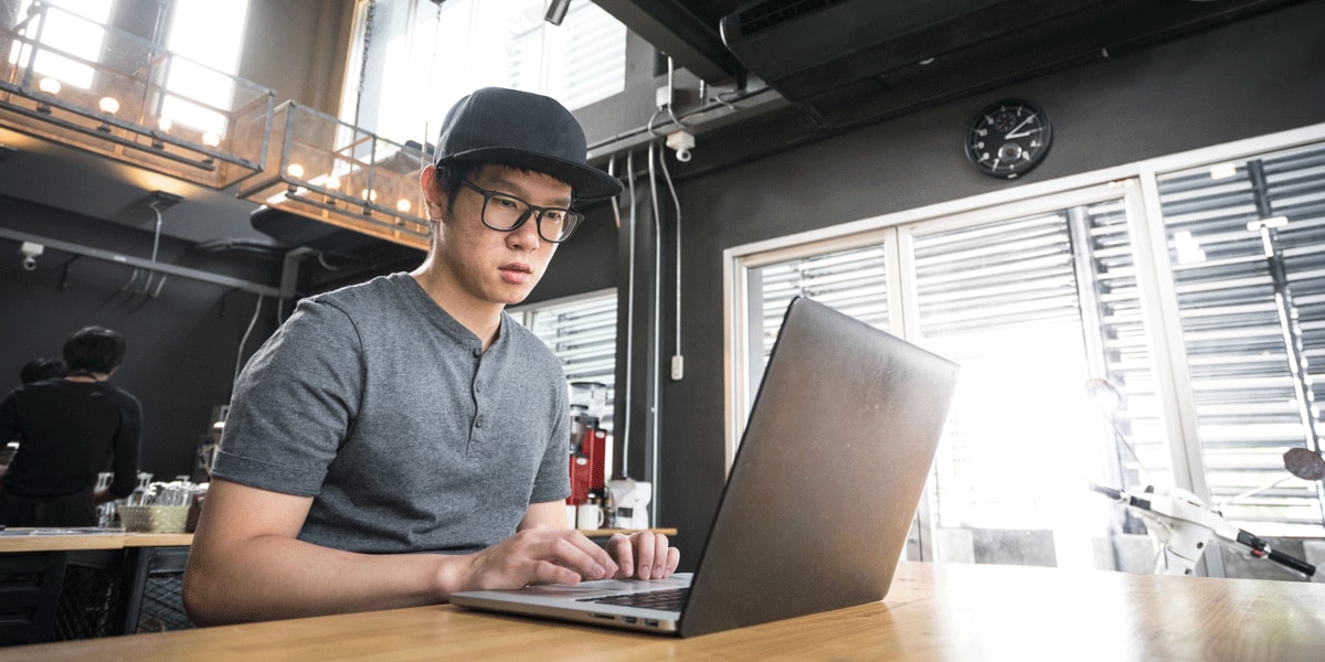 UX portfolio inspiration: A UX bootcamp graduate sitting in front of a laptop, working on his portfolio A UX bootcamp graduate sitting in front of a laptop, working on his portfolio