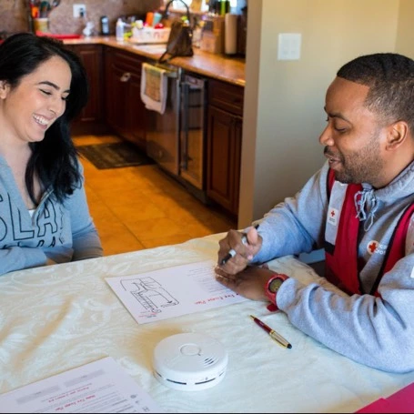 red cross volunteer looking over papers with woman